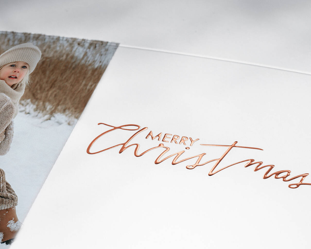 Merry Christmas in beautiful script on a card surrounded by winter motifs.