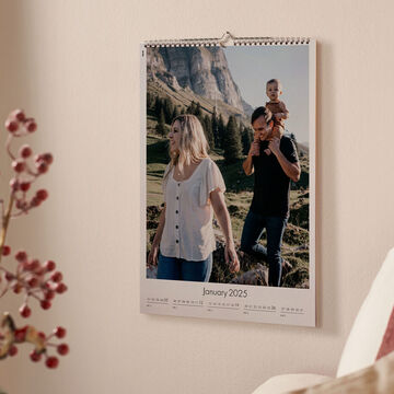 A wall calendar with a romantic image surrounded by colorful flowers and a gift package