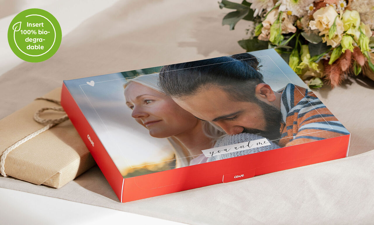 A lovingly designed CEWE photo book on a table, surrounded by eco-friendly gifts and flowers.