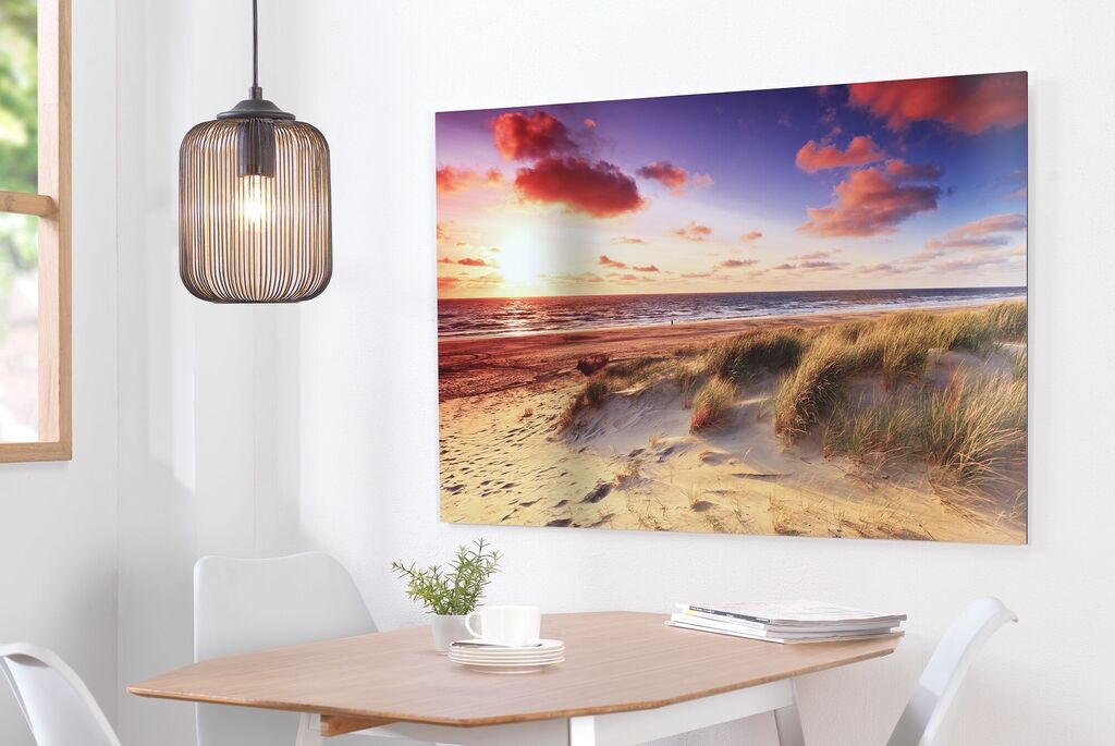 Lovely wall picture of a beach at sunset, with gentle waves and clouds.