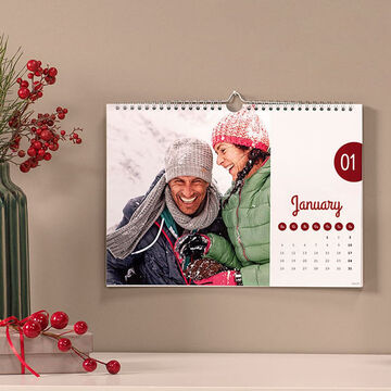 A creative calendar set in a warm winter month, beautifully decorated with a green vase and red berries.