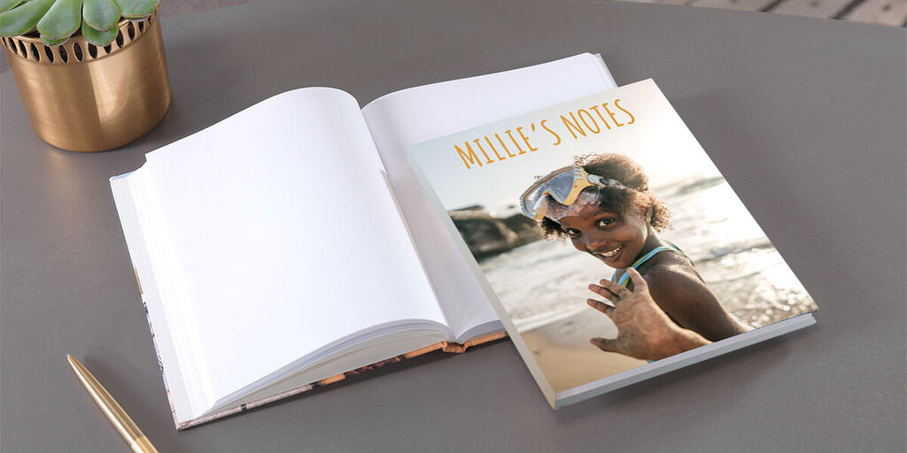 Open photo book with a colorful cover and elegant design, lying on a table.