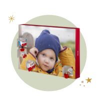 A creative wall picture with a cheerful child in a yellow coat and blue hat, framed with decorative elements.