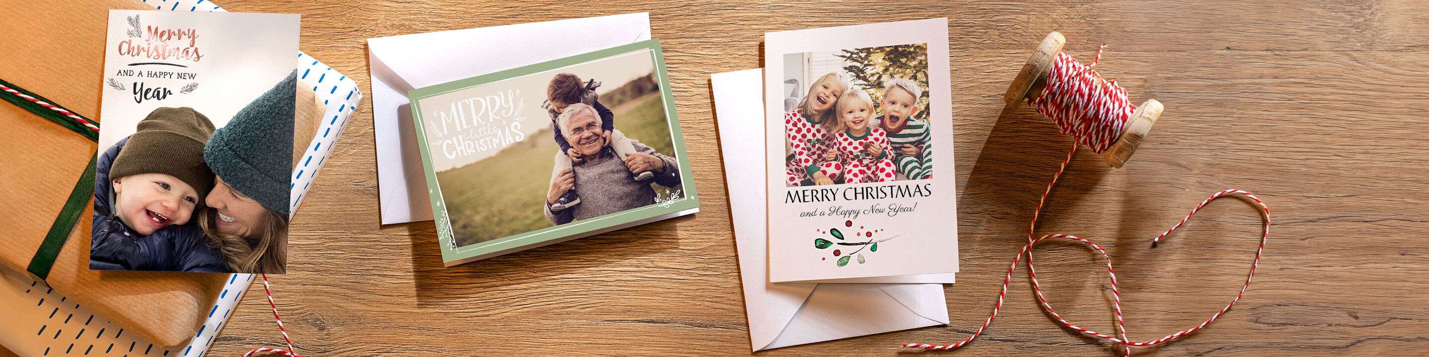 Three different designs of CEWE greeting cards on a wooden table.
