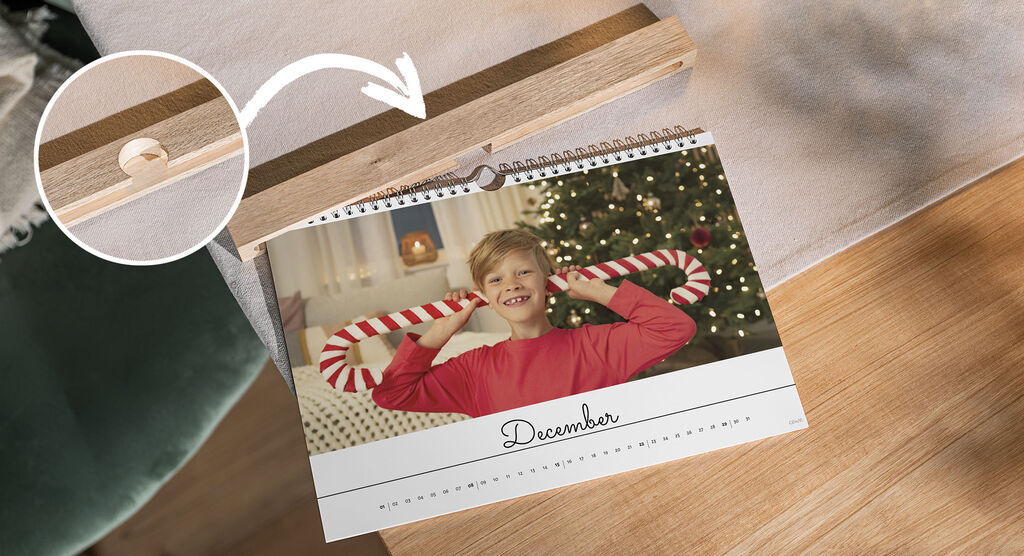 A handmade photo calendar for December with a festively decorated background and a loved one holding a mint candy with a smile.