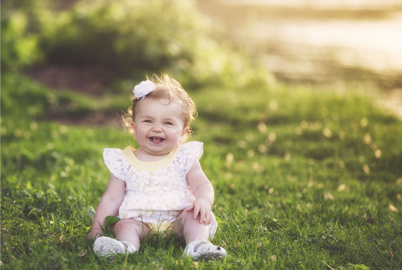 A small child sits on the meadow enjoying nature in the sunlight