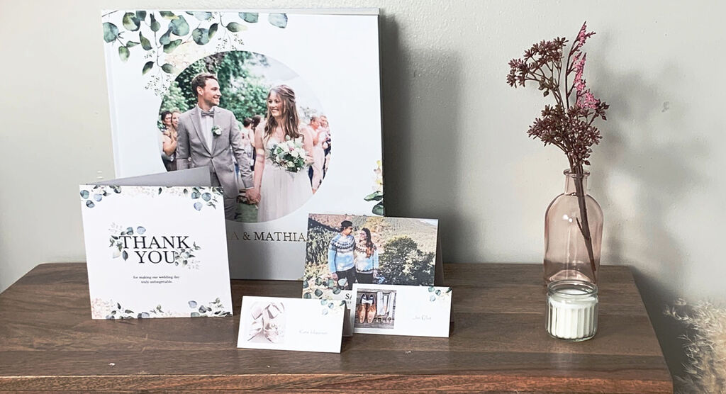 A beautiful set including a photo book, a thank you card, and several photos showcasing love and joy. CEWE photo book.