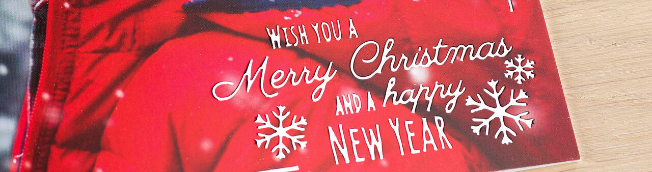 A festive Christmas card with the text 'Wish you a Merry Christmas and a Happy New Year' on a red background with snowflakes.