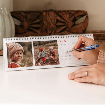 A person views a month in the calendar with pictures of children