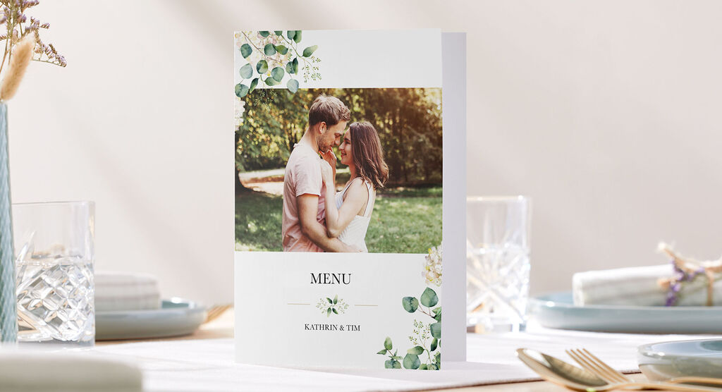 A beautifully designed menu for a wedding features a couple outdoors, elegantly decorated with floral elements.