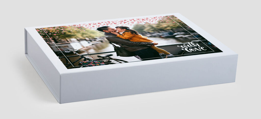 A lovingly designed CEWE photo box featuring a romantic couple on the lid, showing a happy embrace.